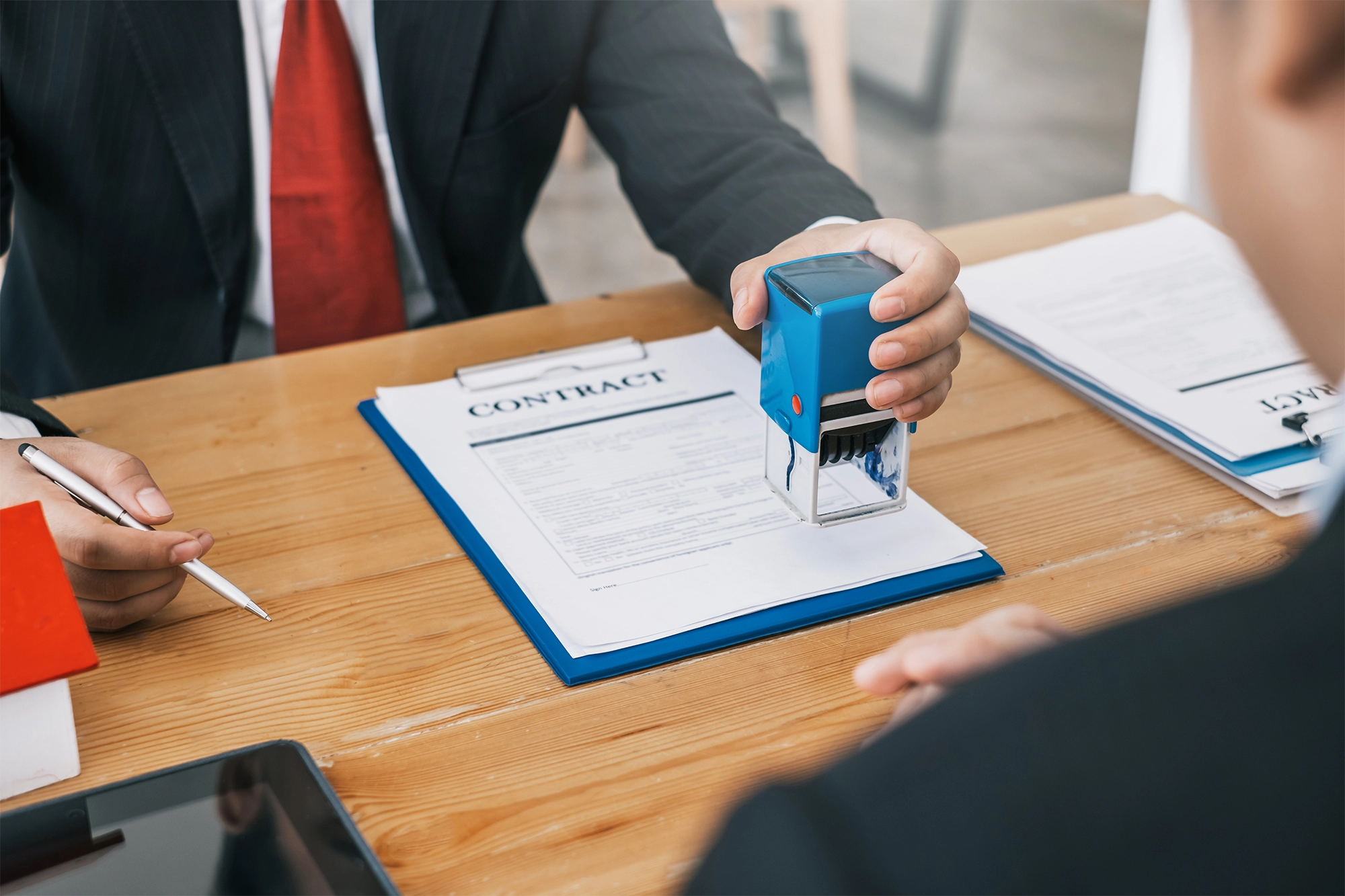 A picture of a contract being stamped with a signature as part of the international recruitment for foreign workers process.