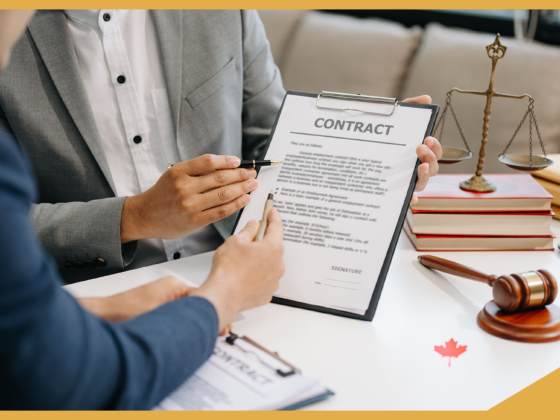 The image is of two people sitting at a desk reviewing an employment contract together, there is a Canadian flag on the desk, a second copy of the contract.