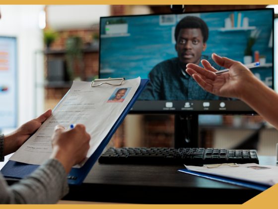 The image shows two employers conducting a video interview with an international candidate. One of the employers is making notes to the resume.