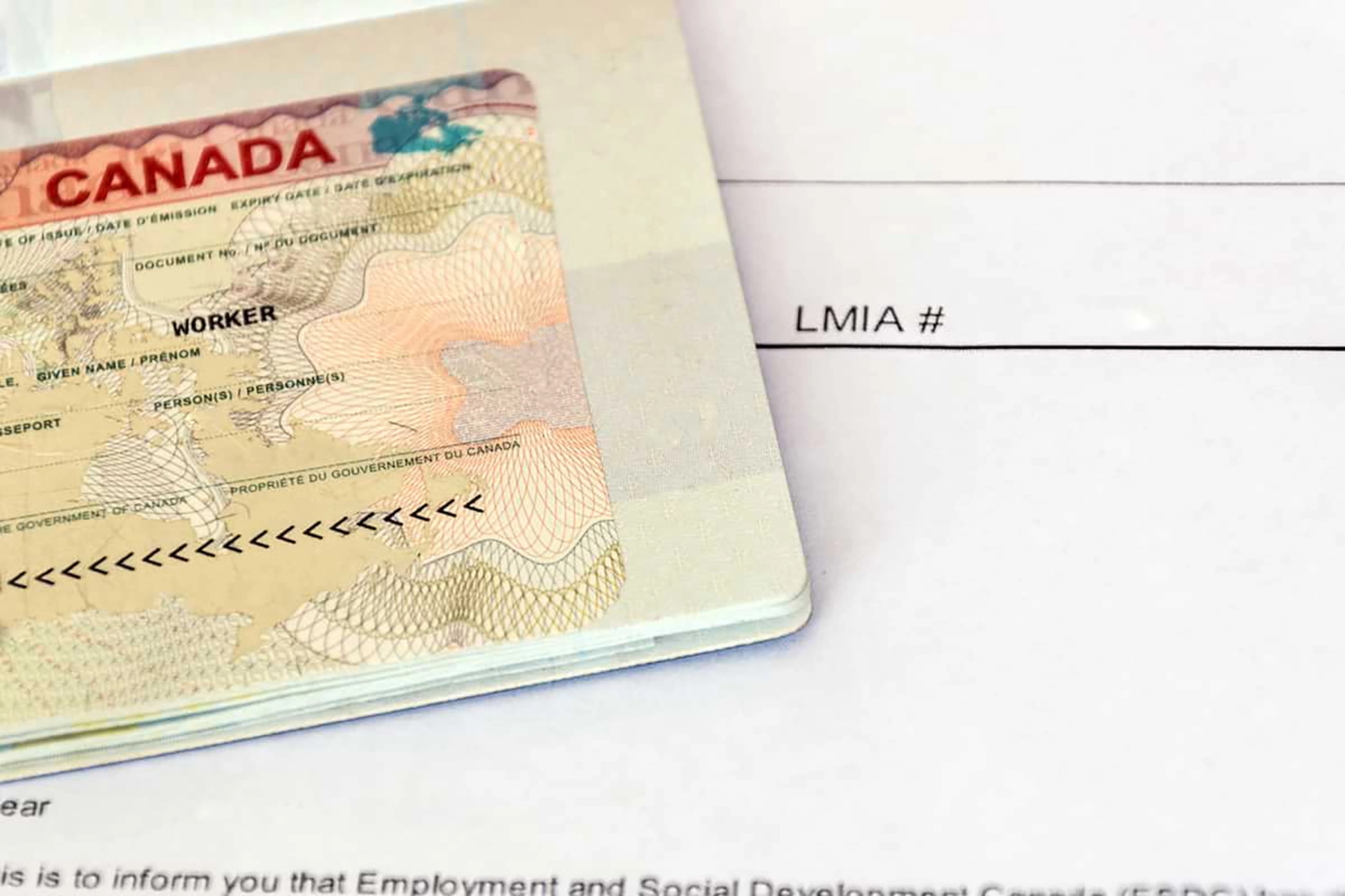 Close up of a Canadian passport and a Canadian Labour Market Impact Assessment (LMIA).