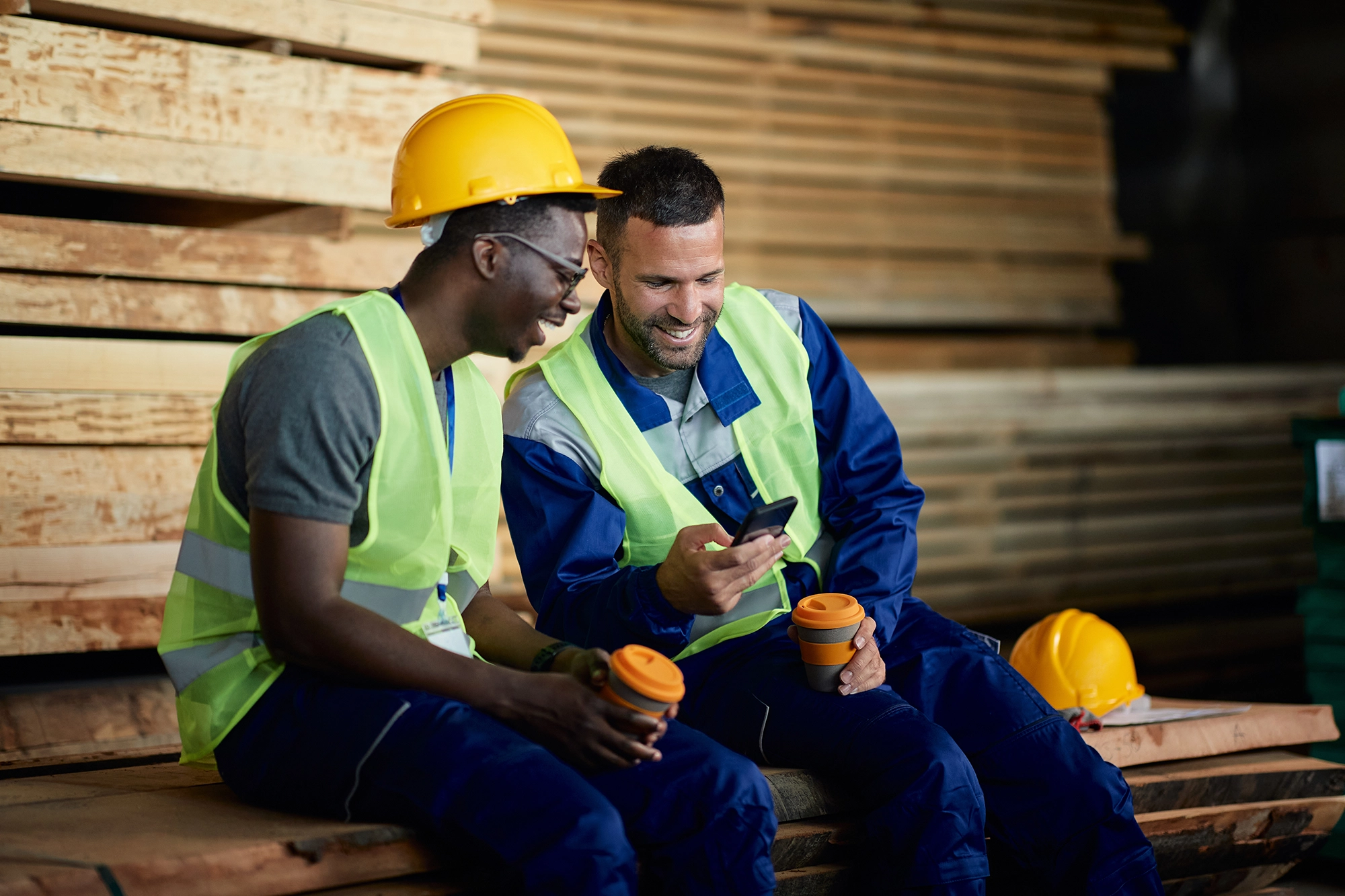 Two construction workers are laughing and bonding together during a break.