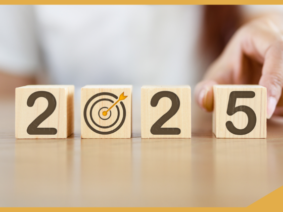 Wooden blocks showing '2025' with a target symbol replacing '0,' symbolizing focus and goals for the year. A hand adjusts the blocks, representing strategic planning and international recruitment goals for the future.